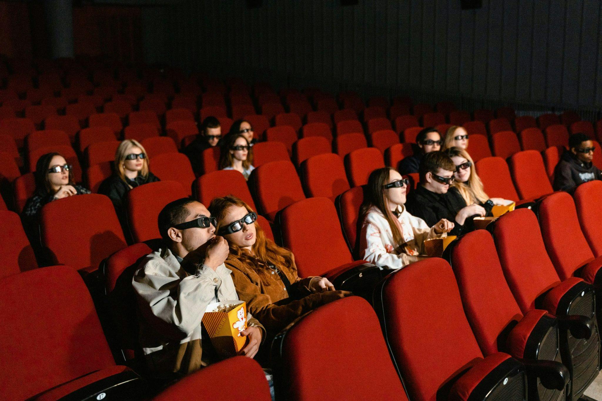 people sitting in cinema wearing 3D glasses