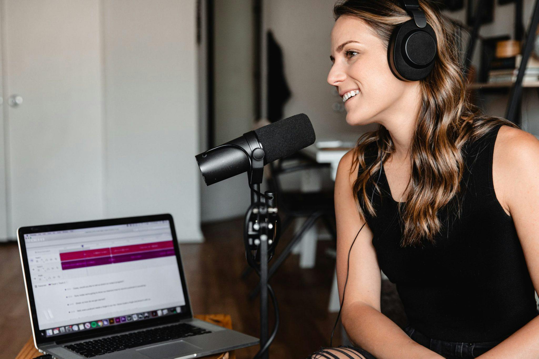woman sitting in front of podcast microphone creating a brand voice