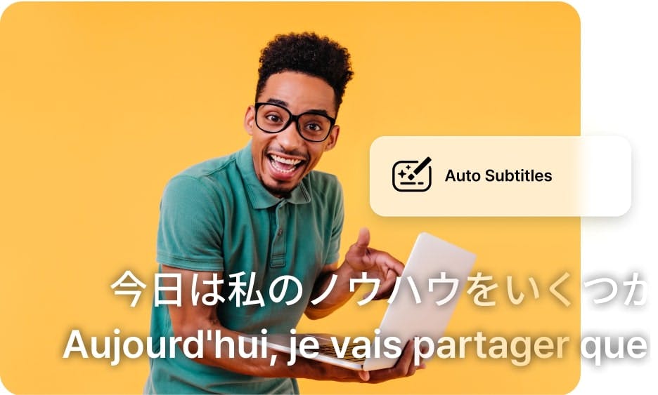 guy with glasses and a green shirt holding his laptop while smiling and multilingual subtitles shown at the bottom of the image